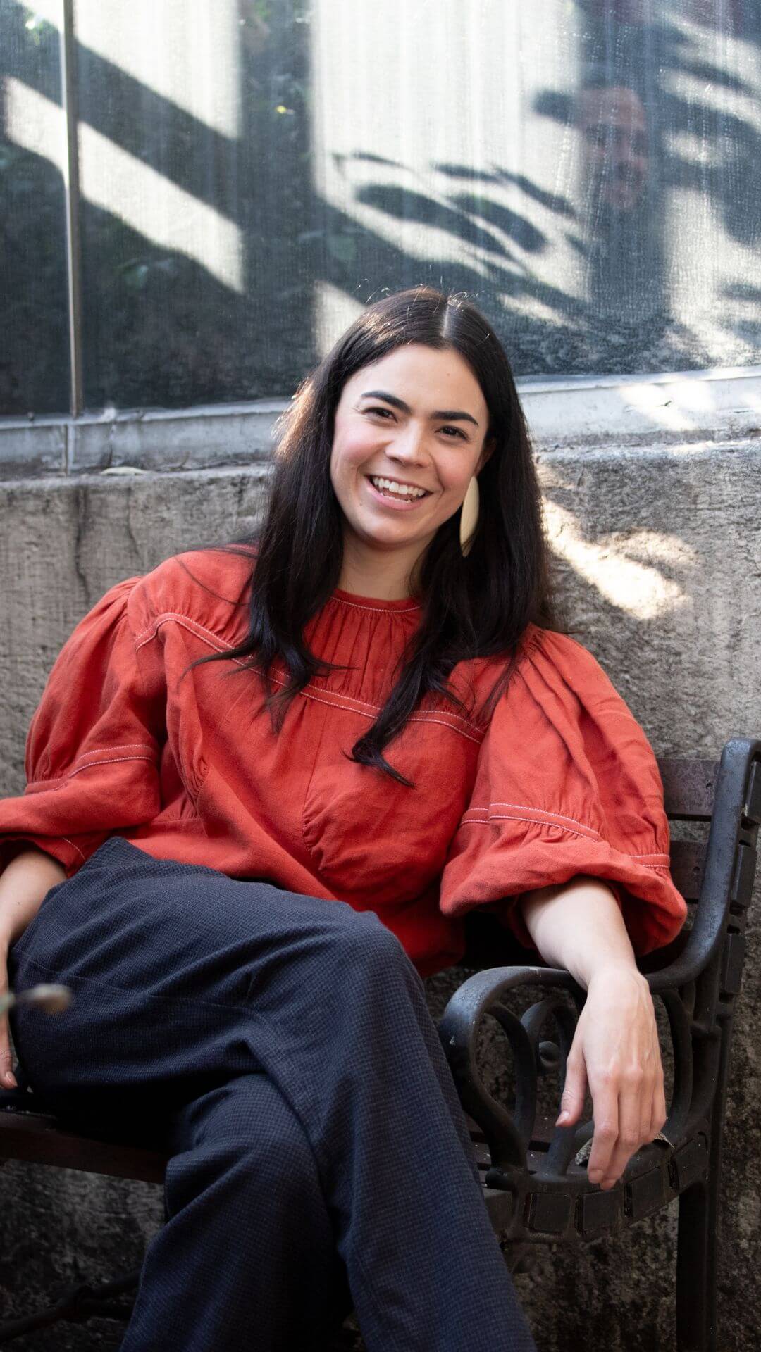 Femme assise, regardant la caméra en souriant