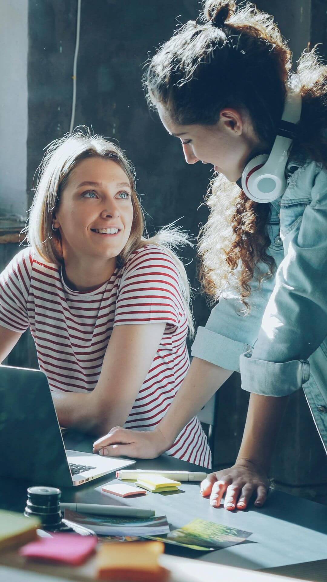 Femmes se regardant en souriant devant un ordinateur